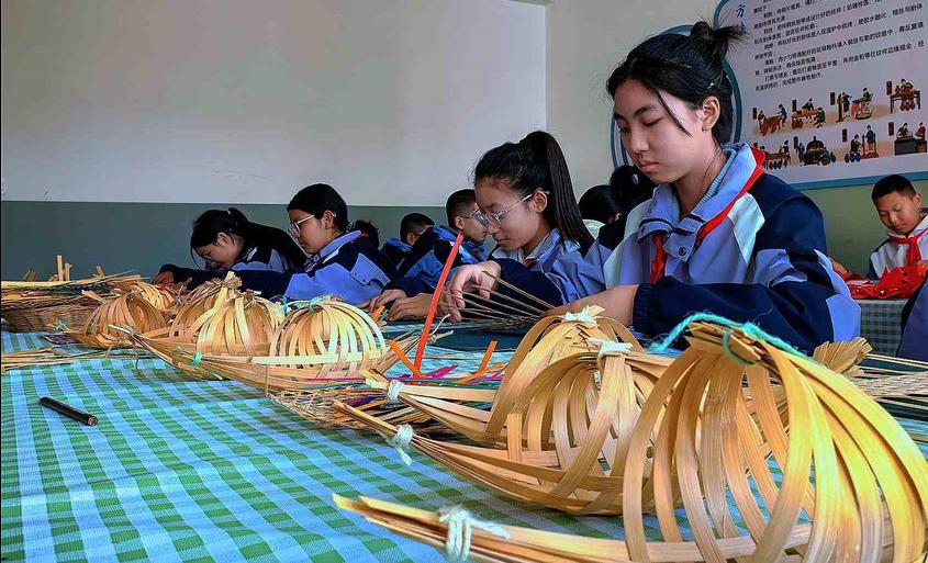 11 月 25 日，在昌吉州第四中学非遗展厅，同学们正在学习编竹。移志向摄