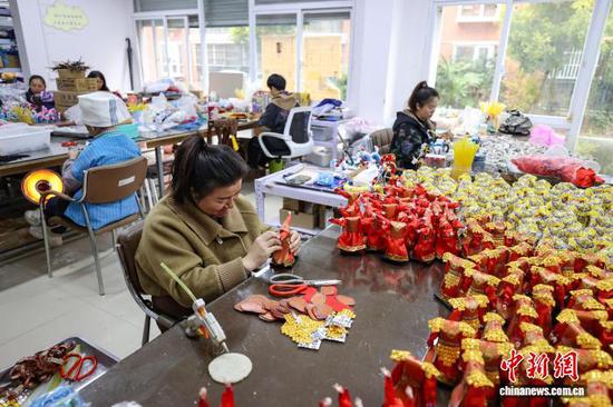 图为工人们在制作唐娃娃。中新社记者 瞿宏伦 摄