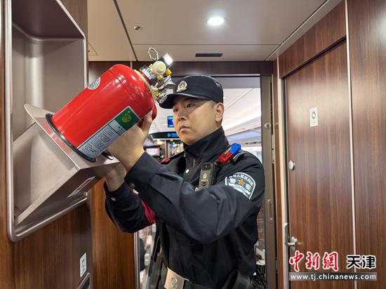 图为北京铁路公安局天津公安处乘警在检查列车消防设施，确保列车行车安全。(北京铁路公安局天津公安处供图)