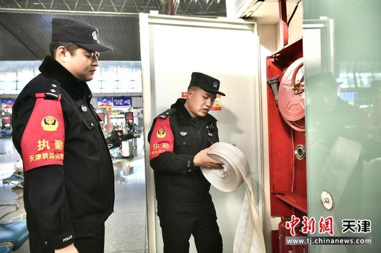 图为北京铁路公安局天津公安处天津站派出所民警在候车大厅检查消防设施，确保旅客平安出行。(北京铁路公安局天津公安处供图)