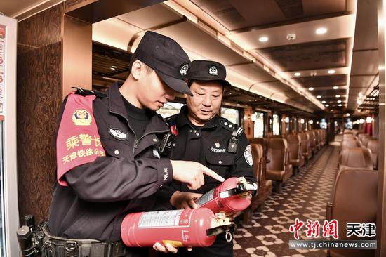图为津旅时光好列车乘警在出发前检查列车消防设施，保证行车安全。(北京铁路公安局天津公安处供图)