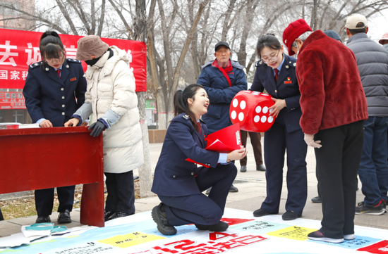 玛纳斯县税务局联合属地司法局举办宪法宣传“游园会”，通过“宪法飞行棋”等互动项目，让群众在“趣”学宪法中增强税收法治意识。魏佳敏 摄e