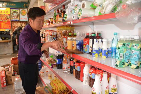 图为贾明文正在打理店内商品。吴俊鹏 摄 图为贾明文正在打理店内商品。吴俊鹏 摄