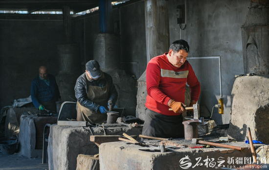 12月2日，阔克旗手工艺专业合作社，艾买提·亚森（中）和家人在制作坎土曼。