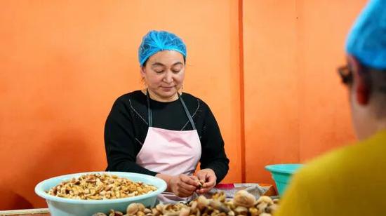 员工古丽尼萨·吾布力卡斯木在脱壳取仁。