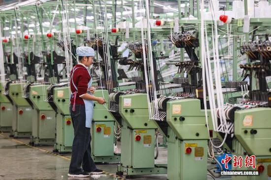 图为工人在查看织带产品加工情况。中新社记者 瞿宏伦 摄 图为工人在查看织带产品加工情况。中新社记者 瞿宏伦 摄