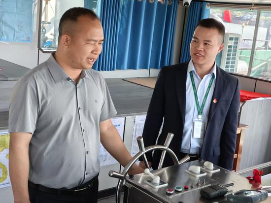 图为邮储银行工作人员向王榜朝了解企业船舶运营情况。罗先彬 摄