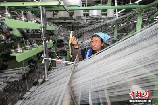 图为工人在处理织带断线。中新社记者 瞿宏伦 摄 图为工人在处理织带断线。中新社记者 瞿宏伦 摄