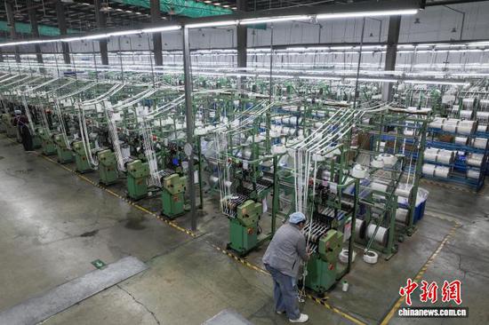 图为工人在查看织带产品加工情况。(无人机照片)中新社记者 瞿宏伦 摄 图为工人在查看织带产品加工情况。(无人机照片)中新社记者 瞿宏伦 摄