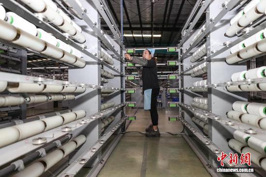 图为工人在查看氨纶线加工情况。中新社记者 瞿宏伦 摄 图为工人在查看氨纶线加工情况。中新社记者 瞿宏伦 摄