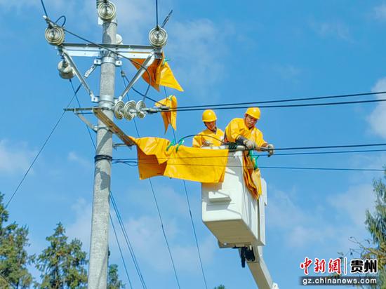 南方电网工作人员在遵义市务川仡佬族苗族自治县大坪镇开展带电作业,保障群众冬季用电无忧。王君辉 摄