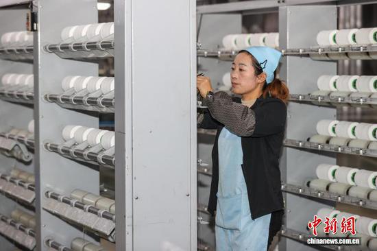 图为工人在查看氨纶线加工情况。中新社记者 瞿宏伦 摄 图为工人在查看氨纶线加工情况。中新社记者 瞿宏伦 摄