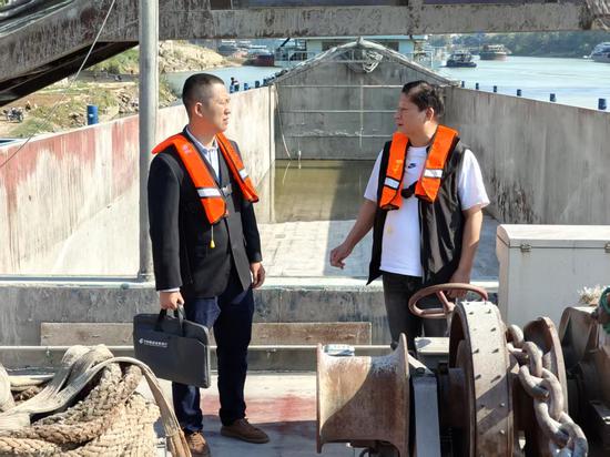 图为邮储银行工作人员向冼伟东了解企业的经营状况。罗先彬 摄