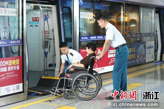 车站工作人员帮助乘坐轮椅的乘客出行。 海宁运营公司 供图 车站工作人员帮助乘坐轮椅的乘客出行。 海宁运营公司 供图
