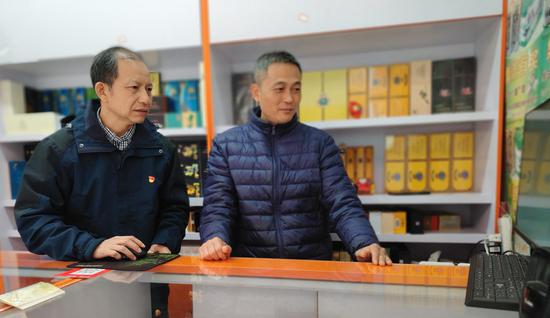 图为陆皆堂指导零售客户使用系统。 许晓杰 摄 图为陆皆堂指导零售客户使用系统。 许晓杰 摄