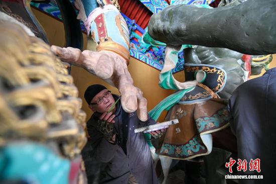 12月10日,天津天后宫,来自国家级非物质文化遗产代表性项目天津泥人张彩塑工作室的工艺美术师们为殿宇内的塑像进行修复。近日,天津天后宫启动了自1986年重建开馆后规模最大、范围最广的一次塑像修复工作。此次修复工作根据“修旧如故”的原则,为天后宫12个殿宇内的46尊塑像进行修复,旨在保留其原有的历史韵味与艺术精髓。中新社记者 佟郁 摄 12月10日,天津天后宫,来自国家级非物质文化遗产代表性项目天津泥人张彩塑工作室的工艺美术师们为殿宇内的塑像进行修复。近日,天津天后宫启动了自1986年重建开馆后规模最大、范围最广的一次塑像修复工作。此次修复工作根据“修旧如故”的原则,为天后宫12个殿宇内的46尊塑像进行修复,旨在保留其原有的历史韵味与艺术精髓。中新社记者 佟郁 摄