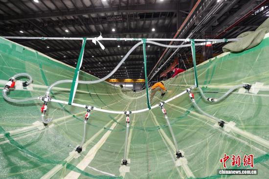 12月11日，工人在对风电叶片壳体进行真空灌注。记者 瞿宏伦 摄