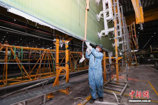 12月11日，工人在撕除风电叶片腹板脱模布。记者 瞿宏伦 摄