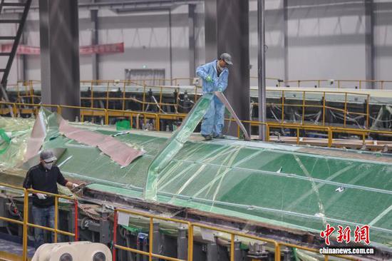 12月11日，工人在撕除风电叶片壳体辅材。记者 瞿宏伦 摄