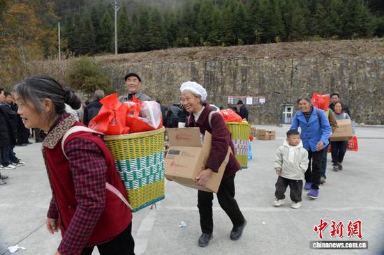 12月10日,凤冈县天桥镇石桥社区分红会现场,该社区1310名民众分别分得2斤大米、半斤红薯粉和一桶洗洁精。 陈昌霖 摄 12月10日,凤冈县天桥镇石桥社区分红会现场,该社区1310名民众分别分得2斤大米、半斤红薯粉和一桶洗洁精。 陈昌霖 摄
