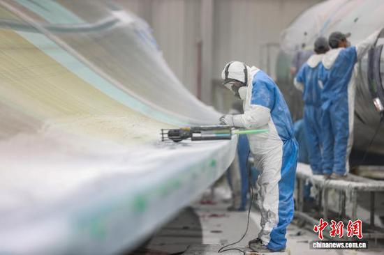 12月11日，工人在打磨风电叶片半成品。记者 瞿宏伦 摄