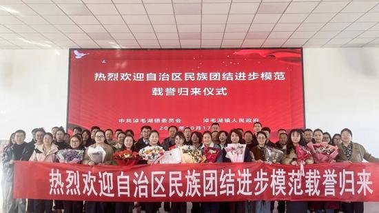 自治区民族团结进步模范载誉归来欢迎仪式现场，所有人员合影留念。2