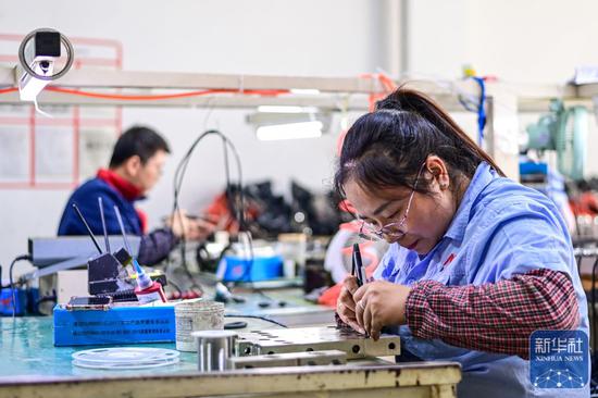 ↑ 11月27日，宁波柯力传感科技股份有限公司员工在生产线上工作。