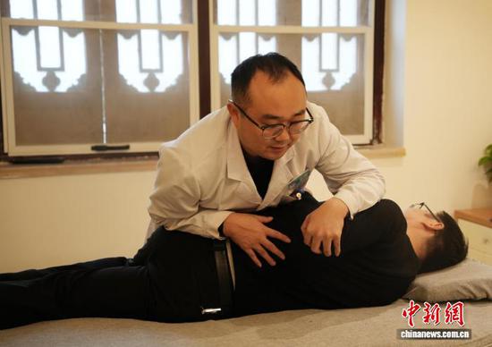 图为医生在贵州省铜仁市石阡县仡佬医馆给就诊患者进行中医正骨。中新网记者 周燕玲 摄