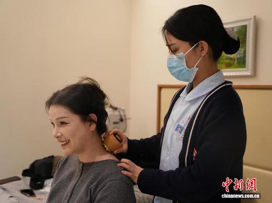 图为年轻人在贵州省铜仁市石阡县仡佬医馆体验火龙罐。中新网记者 周燕玲 摄