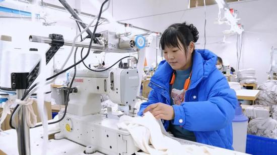 工人在贵州省衫珍轻纺有限公司生产车间操作针车。王治文 摄 工人在贵州省衫珍轻纺有限公司生产车间操作针车。王治文 摄