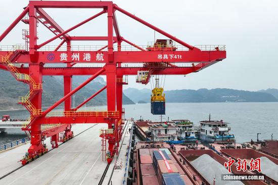 12月16日,起重机在吊装集装箱。当日,随着一台桥式起重机将装有沉淀硫酸钡的集装箱吊入“航电624”货船后起航,贵州首个自动化码头——瓮安港云中港区正式开港。云中港区位于贵州省黔南州瓮安县天文镇乌江干流右岸,是贵州省唯一一个具备专业化、智能化、现代化的港口。(无人机照片) 12月16日,起重机在吊装集装箱。当日,随着一台桥式起重机将装有沉淀硫酸钡的集装箱吊入“航电624”货船后起航,贵州首个自动化码头——瓮安港云中港区正式开港。云中港区位于贵州省黔南州瓮安县天文镇乌江干流右岸,是贵州省唯一一个具备专业化、智能化、现代化的港口。(无人机照片)