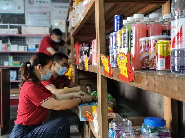 百色烟草客户经理帮助言运周整理店铺。王志昊 摄