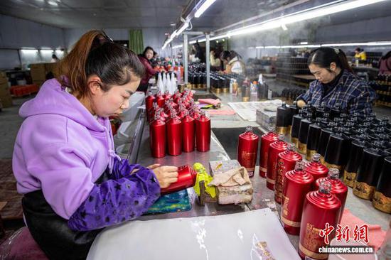 图为工人在金沙县经济开发区一家白酒包装企业车间生产线上作业。史开心 摄 图为工人在金沙县经济开发区一家白酒包装企业车间生产线上作业。史开心 摄