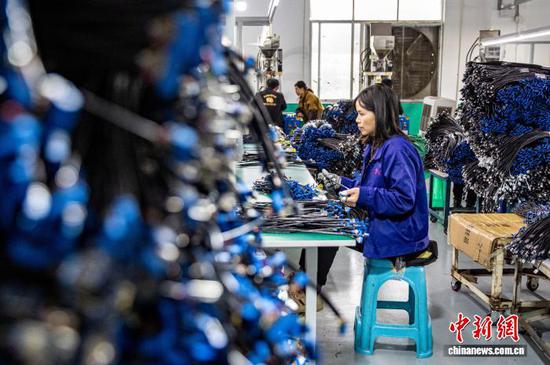 图为工人在金沙县经济开发区一家数据线生产企业车间生产线上作业。史开心 摄 图为工人在金沙县经济开发区一家数据线生产企业车间生产线上作业。史开心 摄