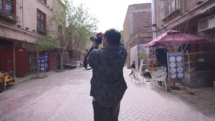 （侨乡故事）在新疆喀什古城“抢顾客风头”的摄影师