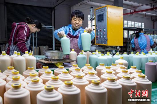 图为工人在金沙县经济开发区一家白酒包装企业车间生产线上作业。史开心 摄 图为工人在金沙县经济开发区一家白酒包装企业车间生产线上作业。史开心 摄
