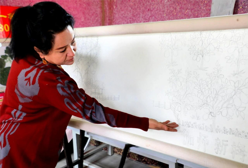 海热古丽·亚热正向记者讲解创作思路。