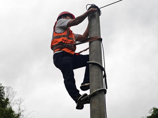图为工程师在拉设光缆。