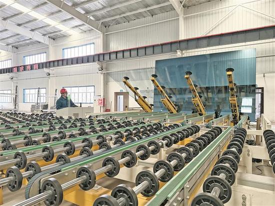 12月16日，在五师双河市荆楚工业园区新疆普耀新型建材有限公司生产车间，工作人员对玻璃镀膜工序进行监测。作为湖北省产业援疆重点项目，该公司依托五师双河市丰富的石英砂、石灰石、白云石等资源优势，着力延长产业链，产品不仅填补了疆内低辐射玻璃生产领域的空白，也满足了本地区及中亚国家的市场需求。周廷瑜 摄