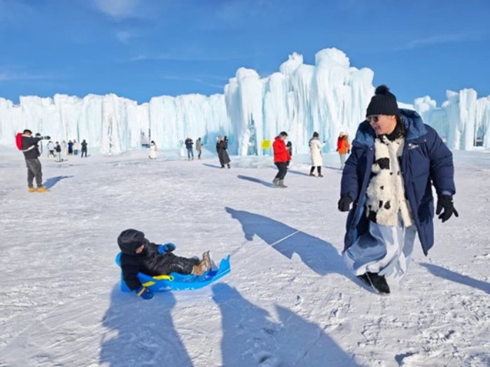 游客在“冰瀑”前打卡拍照、游玩。贾晓雪 摄

