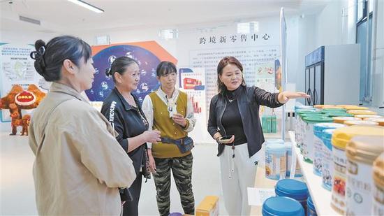 在九师白杨市创新创业基地，工作人员（右一）向参观者介绍辽疆两地的特色产品（资料图片）。为进一步夯实产业承载平台，辽宁省投入援疆资金5200万元，打造九师白杨市创新创业基地。截至目前，该基地已吸引20家企业入驻，孵化项目总投资达114.6亿元，实现进出口贸易额20亿元。兵团日报常驻记者 苟汇敏 摄