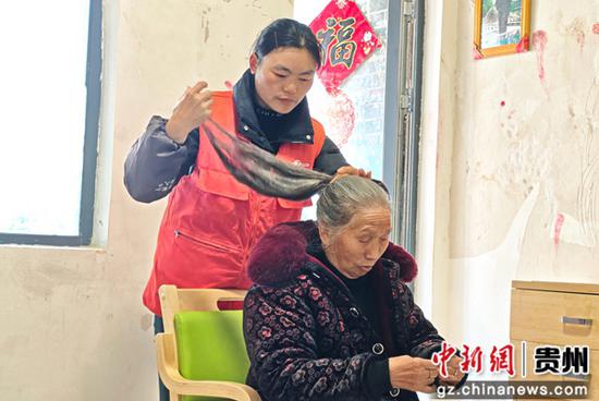 助老员正在为老人梳头发。王月 摄