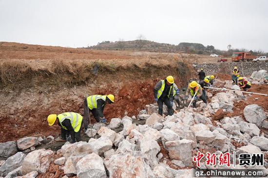 图为12月24日，在威宁自治县2025年高标准农田建设项目迤那镇樱桃村项目区，施工人员分工协作，正在砌筑田坎。陈逍 摄