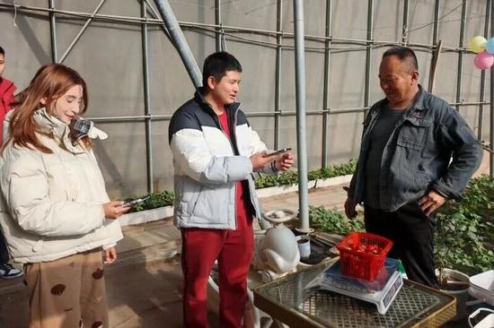 游客购买草莓。古丽阿亚提 摄