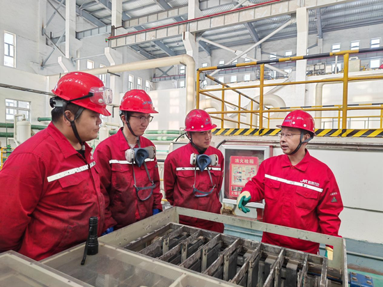 12月30日，在五鑫铜业稀贵车间，外聘技术专家、国家级技能大师夏兴旺带领作业人员查看电解设备，确保年末生产平稳有序。图片由五鑫铜业稀贵车间 靳峰峰 提供