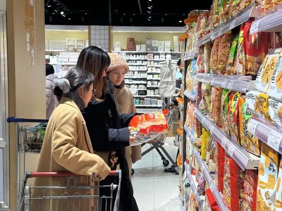 闲暇时分，好友结伴选购水果，享受节日前的乐趣。伊尔番 摄