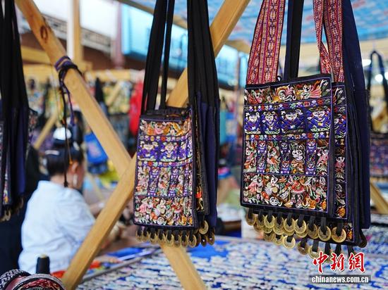 凯里传承刺绣、挑花、银饰、芦笙等民族工艺，享有“百节之乡”“芦笙的故乡”“东方斗牛之乡”等佳誉，被联合国世界文化保护基金会列为“返璞归真，重返自然世界十大旅游景区”和“世界少数民族文化保护圈”。图为凯里绣里淘非遗集市上售卖的苗绣包。周燕玲摄