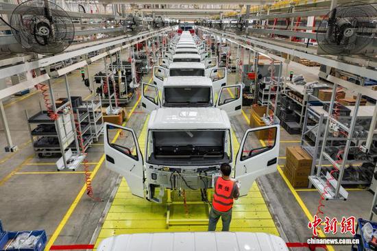 图为工人在贵安新区一家新能源汽车制造企业总装车间安装新能源轻卡车零部件。 中新网记者瞿宏伦 摄 图为工人在贵安新区一家新能源汽车制造企业总装车间安装新能源轻卡车零部件。 中新网记者瞿宏伦 摄