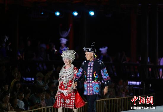 来自美国的游客穿上苗族服饰在贵州“村T”舞台上走秀。李靖 摄