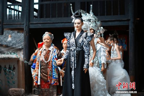 中外模特与当地苗族群众演员同台走秀，共同演绎苗族传统服饰与时尚服饰交融的魅力。